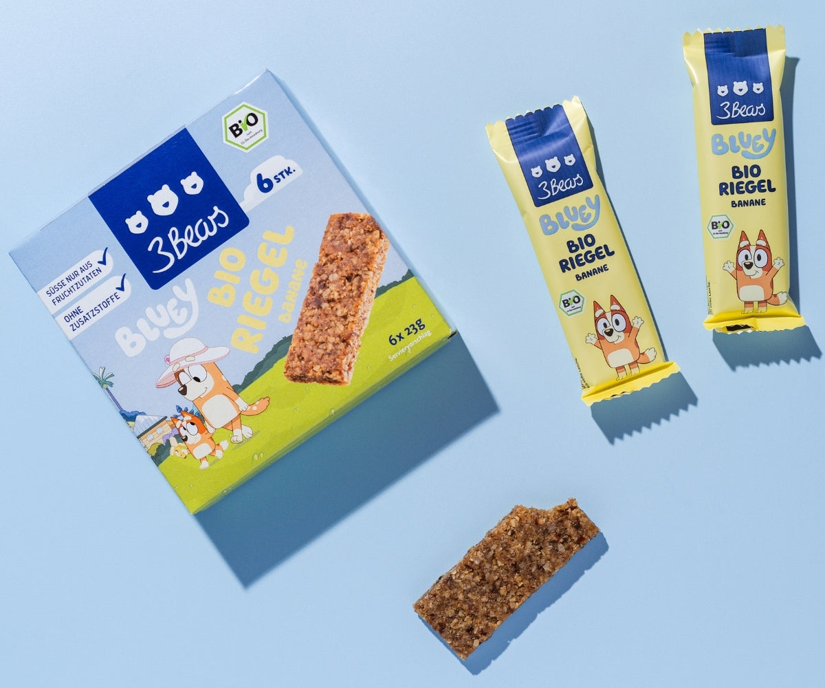 Ungeöffnete Bio Riegel Banane neben einem Riegel ohne Verpackung