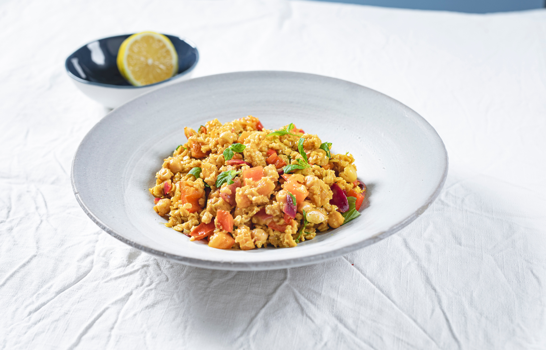 Cremiges Haferrisotto mit Karotten, Kichererbsen und Aprikosen, serviert mit frischer Minze
